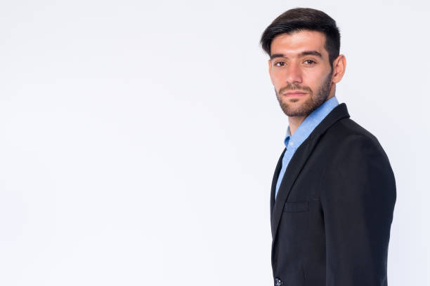 istock Profile view of young bearded Persian businessman looking at camera 1203089612