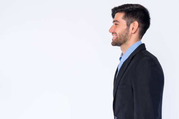 vista del profilo del giovane uomo d'affari persiano barbuto felice in abito sorridente - close up businessman corporate business side view foto e immagini stock