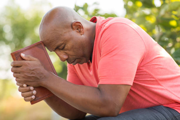 istock African American man praying and reading the Bible. 1203090230