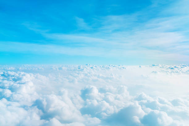 istock Airplane window view above beautiful white cloud summer blue sky and sun light abstract nature background. 1203092110