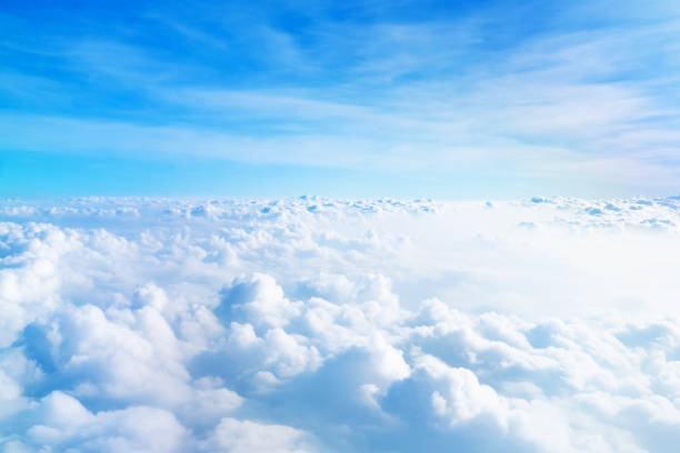istock Airplane window view above beautiful white cloud summer blue sky and sun light abstract nature background. 1203092122