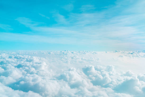 istock Airplane window view above beautiful white cloud summer blue sky and sun light abstract nature background. 1203092133