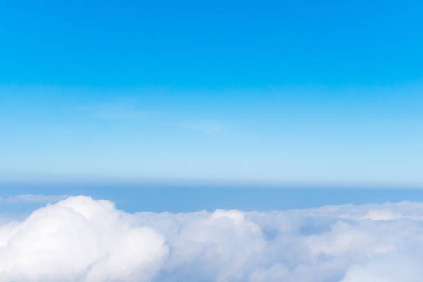 istock Airplane window view above beautiful white cloud summer blue sky and sun light abstract nature background. 1203092178