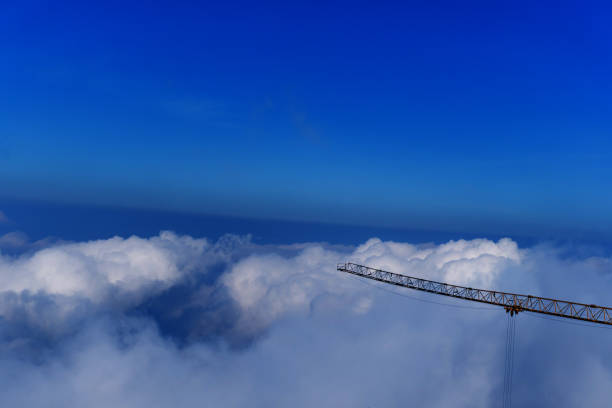 A crane is a type of machine above beautiful white cloud summer blue sky and sun light abstract nature background.