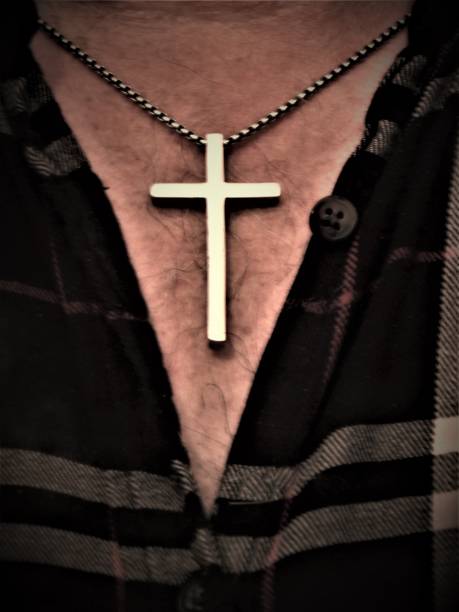 Isolated Close Up of Man's Necklace - Silver Cross - Religious Jewelry- Open Flannel Shirt Reveal Man's Necklace - Symbols of Christianity - Wearing The Cross Symbol - Larger Silver Cross Hangs Around Man's Neck on Its Silver Chain - Powerful Imagery - Artistic Religious Backgrounds for Website, Blog, or Advertisement - Engaging Photo Art fotografía libre de regalías - collar de plata del hombre cuelga alrededor de su cuello - imagen de cerca de la cruz religiosa - signos de cristianismo - joyería - cruz de plata en la cadena de plata - cruz de plata más grande del hombre en la cadena -