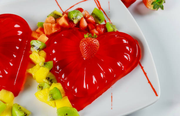 strawberry gelatin decorated with fresh strawberry, kiwi and pineapple. - raspberry heart shape gelatin dessert valentines day imagens e fotografias de stock