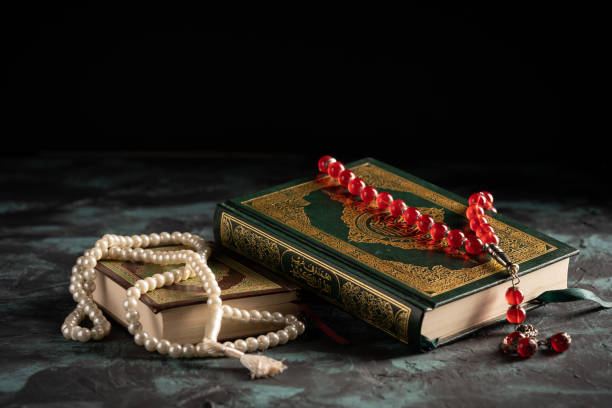 istock Islamic concept: The holy Quran and Tasbih (prayer beads beads) on dark background 1203114701