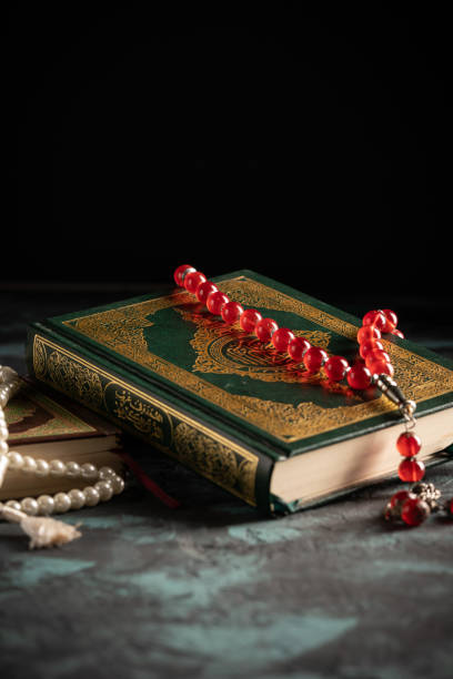 istock Islamic concept: The holy Quran and Tasbih (prayer beads beads) on dark background 1203114713
