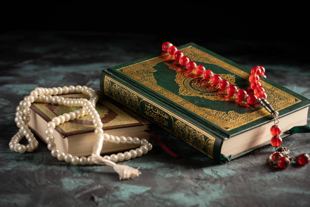 istock Islamic concept: The holy Quran and Tasbih (prayer beads beads) on dark background 1203114732
