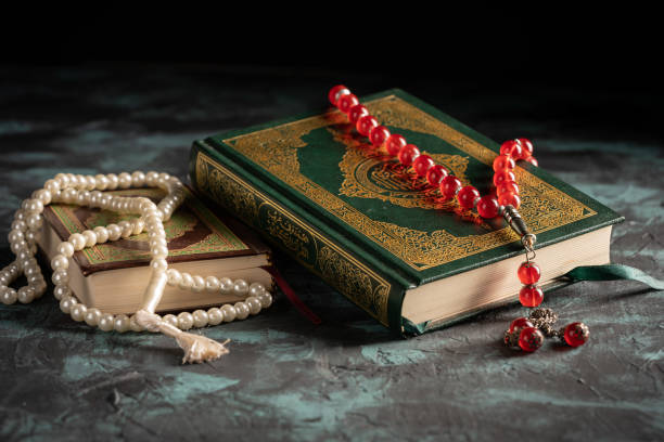 istock Islamic concept: The holy Quran and Tasbih (prayer beads beads) on dark background 1203114758