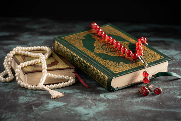 istock Islamic concept: The holy Quran and Tasbih (prayer beads beads) on dark background 1203114780