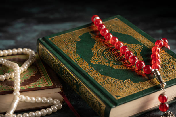 istock Islamic concept: The holy Quran and Tasbih (prayer beads beads) on dark background 1203114798