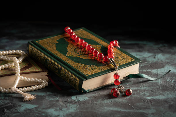 istock Islamic concept: The holy Quran and Tasbih (prayer beads beads) on dark background 1203114812