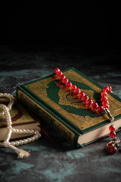 istock Islamic concept: The holy Quran and Tasbih (prayer beads beads) on dark background 1203114831