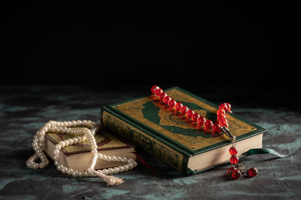 istock Islamic concept: The holy Quran and Tasbih (prayer beads beads) on dark background 1203114863