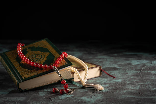 istock Islamic concept: The holy Quran and Tasbih (prayer beads beads) on dark background 1203114877
