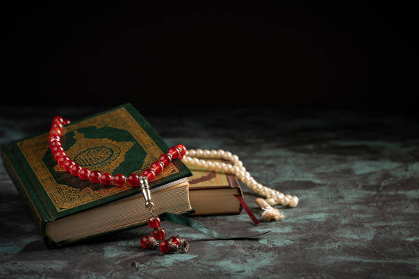 istock Islamic concept: The holy Quran and Tasbih (prayer beads beads) on dark background 1203114889