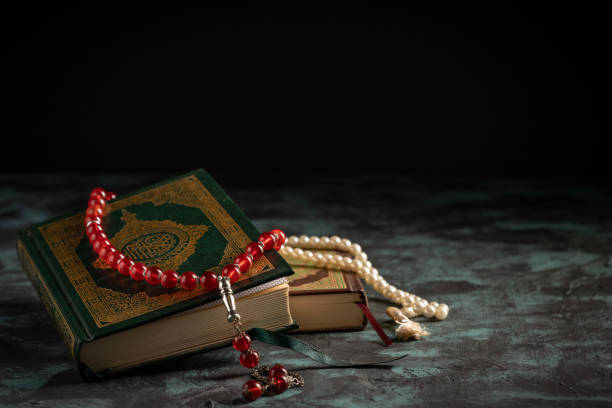 istock Islamic concept: The holy Quran and Tasbih (prayer beads beads) on dark background 1203114896