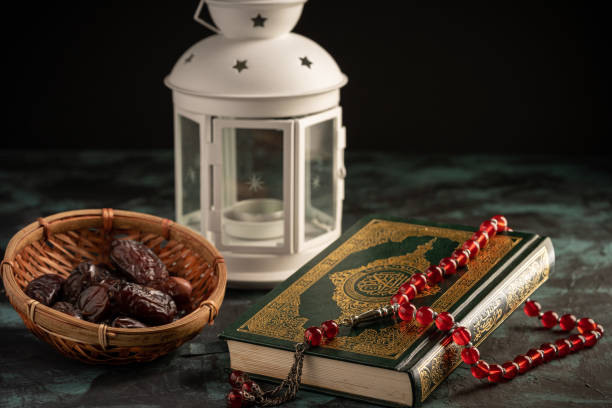 istock Islamic concept: The holy Quran and Tasbih (prayer beads beads) on dark background 1203114981