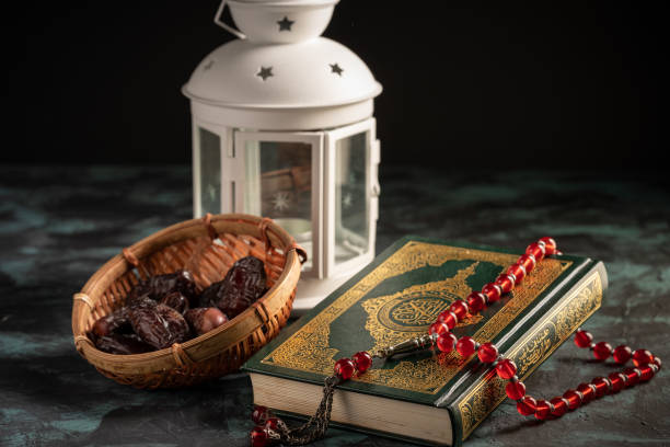 istock Islamic concept: The holy Quran and Tasbih (prayer beads beads) on dark background 1203115491