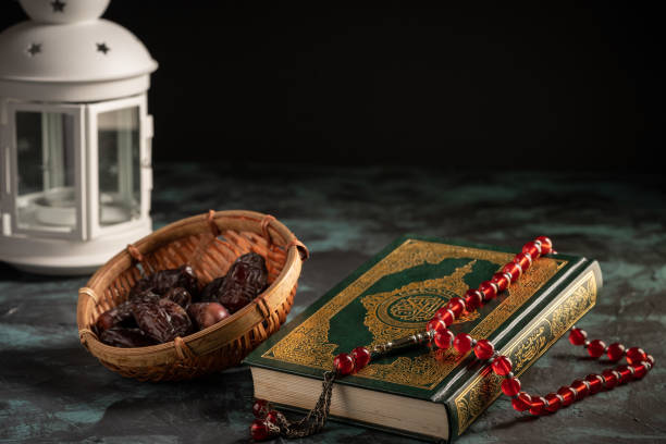 istock Islamic concept: The holy Quran and Tasbih (prayer beads beads) on dark background 1203115514
