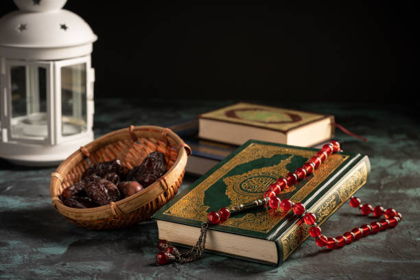 istock Islamic concept: The holy Quran and Tasbih (prayer beads beads) on dark background 1203115527