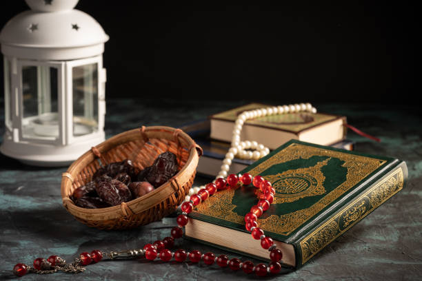 istock Islamic concept: The holy Quran and Tasbih (prayer beads beads) on dark background 1203115548