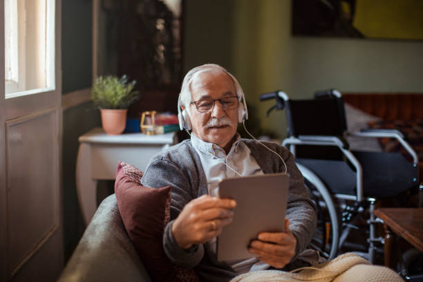 senior man using a tablet at home - white dog audio imagens e fotografias de stock