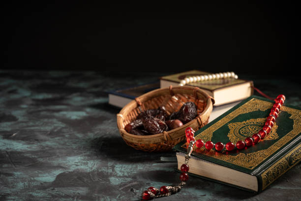 istock Islamic concept: The holy Quran and Tasbih (prayer beads beads) on dark background 1203115565