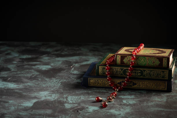istock Islamic concept: The holy Quran and Tasbih (prayer beads beads) on dark background 1203115588