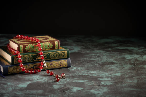 istock Islamic concept: The holy Quran and Tasbih (prayer beads beads) on dark background 1203115597