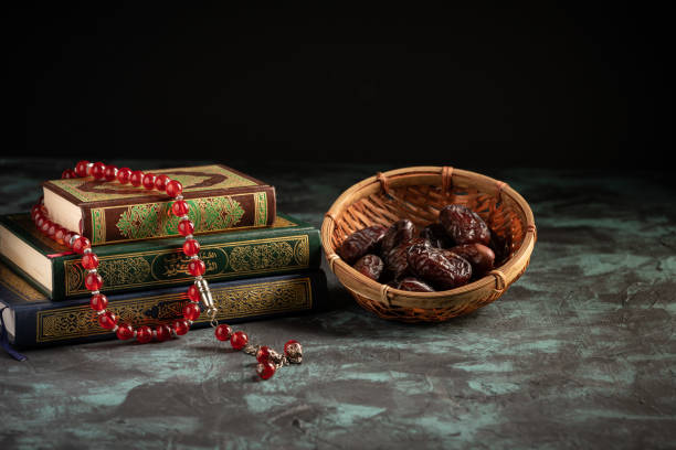 istock Islamic concept: The holy Quran and Tasbih (prayer beads beads) on dark background 1203115604