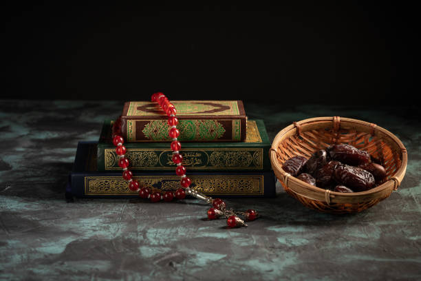 istock Islamic concept: The holy Quran and Tasbih (prayer beads beads) on dark background 1203115610