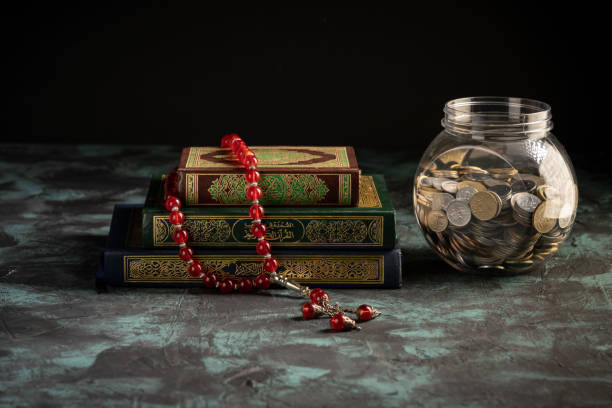 istock Islamic concept: The holy Quran and Tasbih (prayer beads beads) on dark background 1203115621