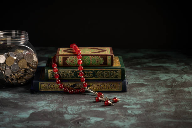 istock Islamic concept: The holy Quran and Tasbih (prayer beads beads) on dark background 1203115640