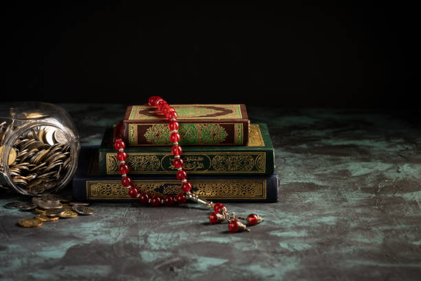 istock Islamic concept: The holy Quran and Tasbih (prayer beads beads) on dark background 1203115658