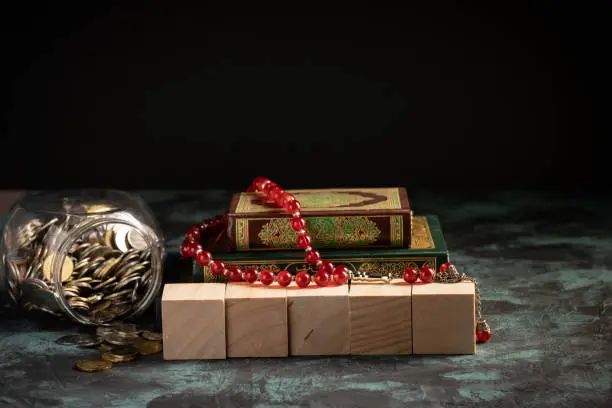 Islamic concept: The holy Quran and Tasbih (prayer beads beads) on dark background
