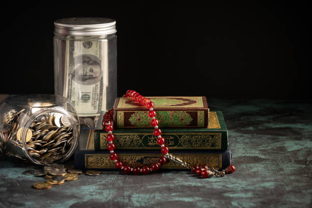 istock Islamic concept: The holy Quran and Tasbih (prayer beads beads) on dark background 1203115743