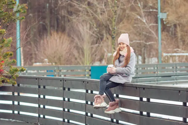 Adorable little girl on the ice-rink outdoors