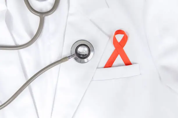 Closeup of a red ribbon inserted to lab coat's pocket, isolated in white lab coat background