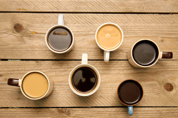 istock Many cups with tasty aromatic coffee  on wooden table. Top view with copy space 1203117040