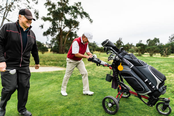 istock Smiling senior man pushing his clubs on a golf course 1203117799