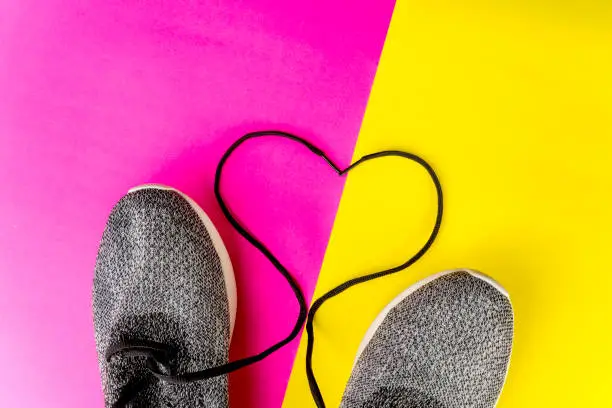Flat layout of heart shaped shoelaces, isolated in red and yellow background