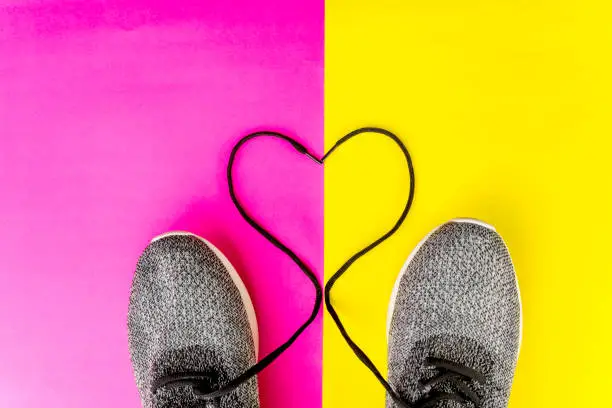 Flat layout of heart shaped shoestrings, isolated in red and yellow background