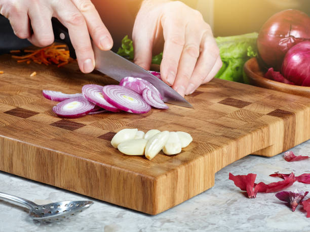 istock male cook cuts raw onions 1203120671