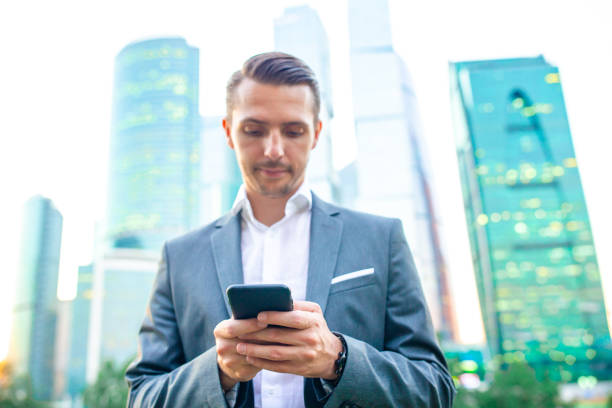 istock Young caucasian man holding smartphone for business work. 1203121927