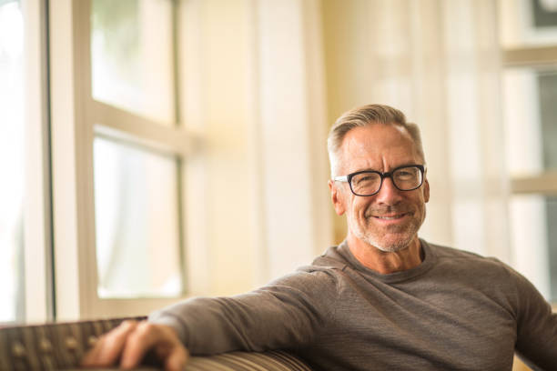 istock Portarit of a handsome older man sitting on a sofa. 1203123301