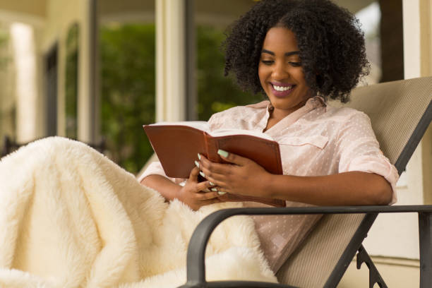 istock Woman smiling holding a book. 1203124205