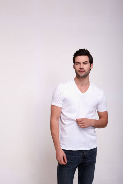 istock Handsome young man in casual white top on a bright white background. 1203124388