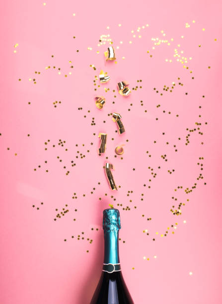 grüne champagnerflasche und streamer fließen auf rosa - mint liquor stock-fotos und bilder